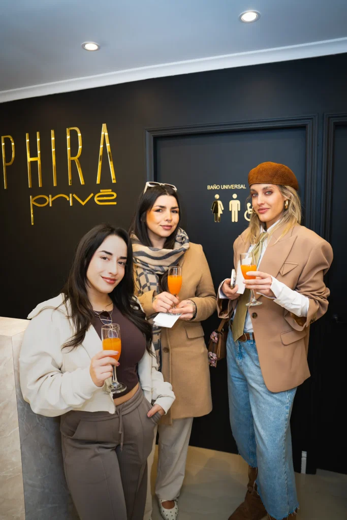 Invitadas conversando frente al muro de marca de Sapphira Privé