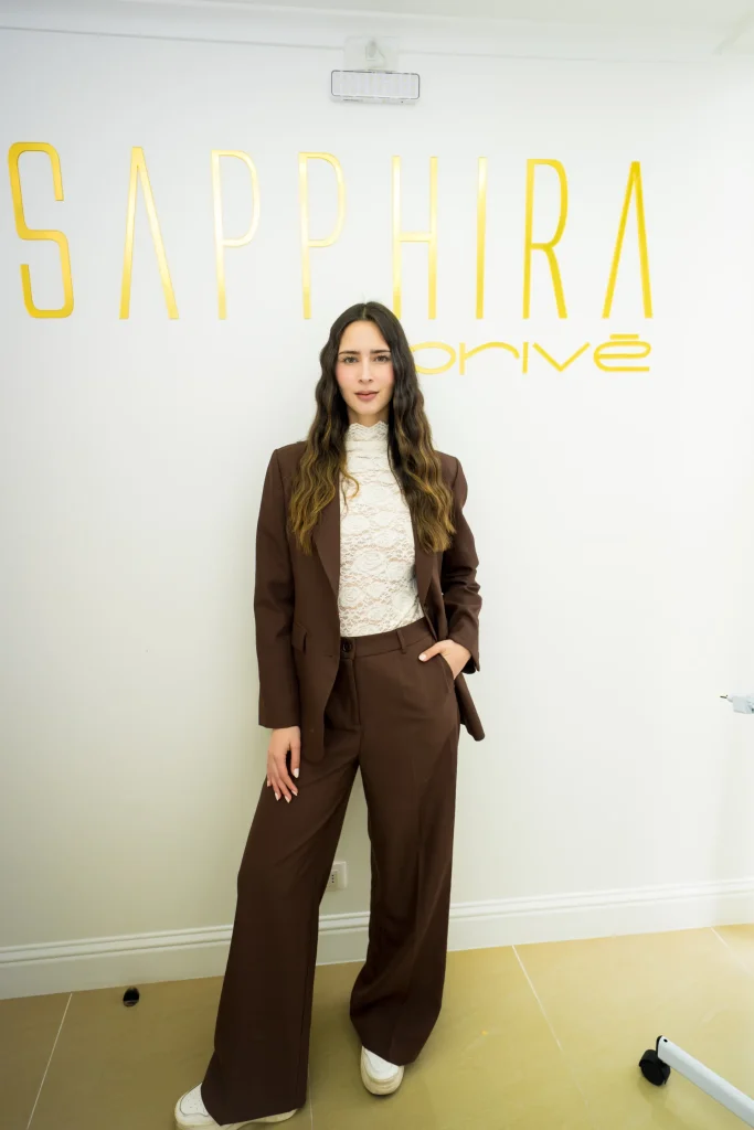 Asistente frente al logo de Sapphira Privé durante el lanzamiento en Providencia