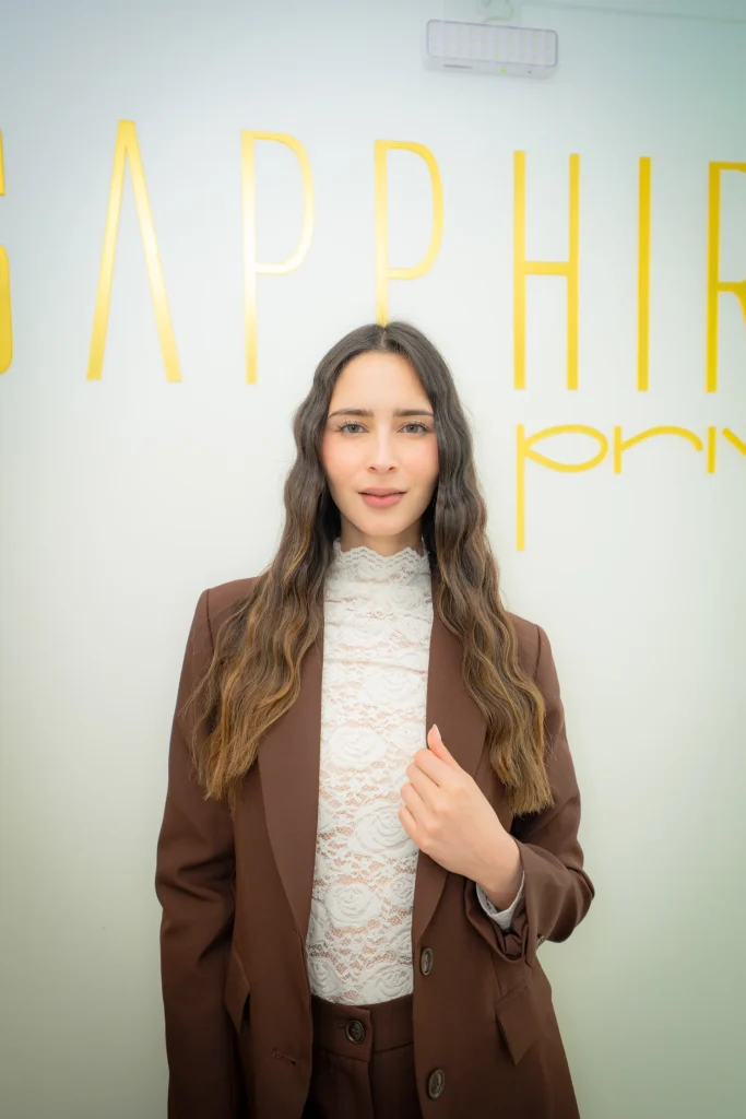 Invitada posando frente al muro de marca de Sapphira Privé en Providencia
